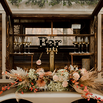 Floral center piece on vintage mobile horse box bar